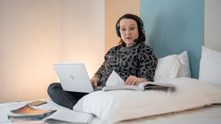 Une étudiante installée sur son lit pour étudier
